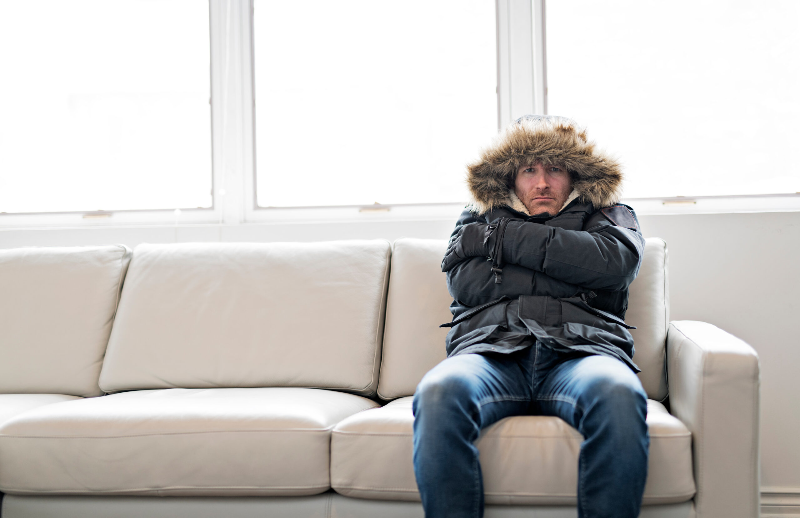 Man With Warm Clothing Feeling The Cold Inside House on the sofa