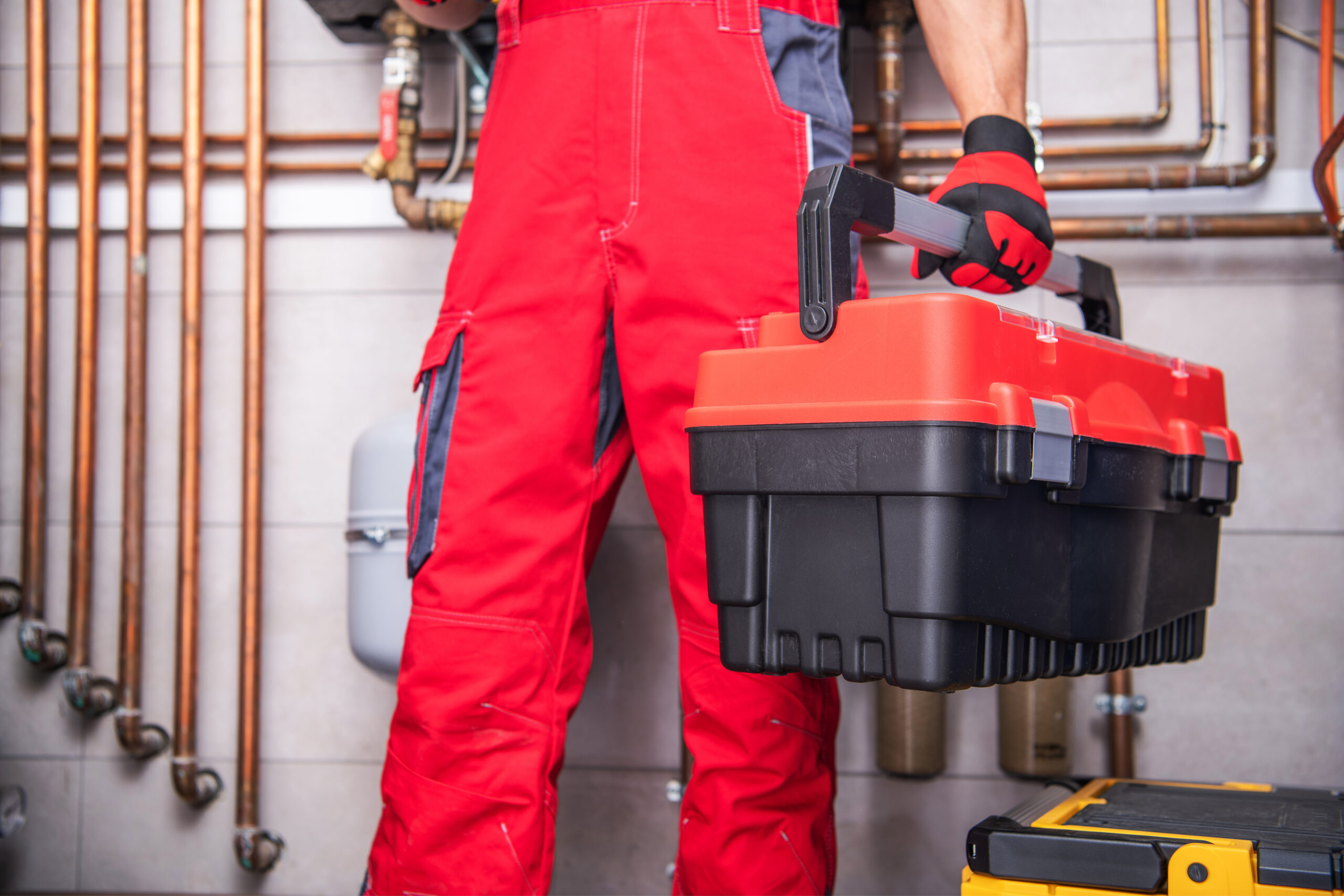 hvac technician holding tool box during furnace installation