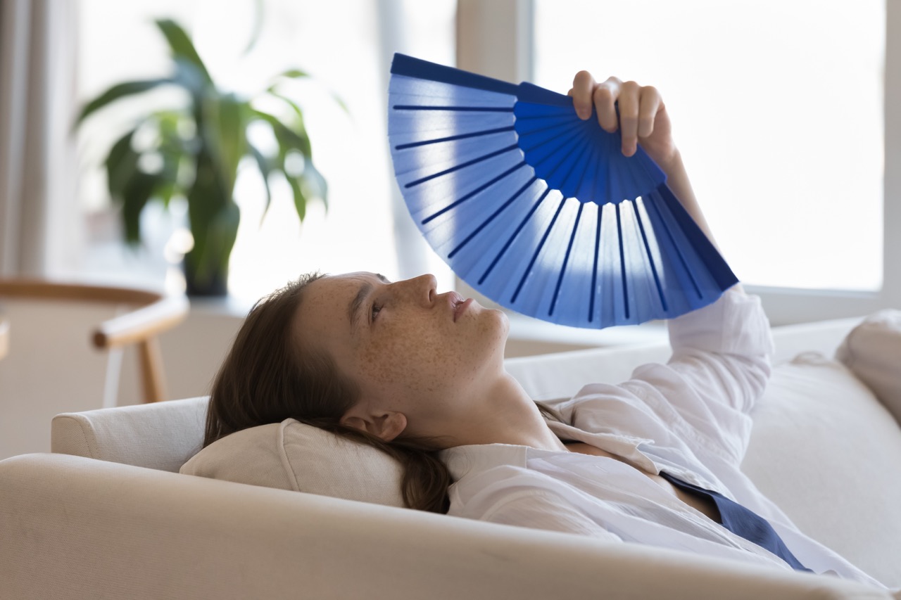 Girl using a handheld fan to stay cool