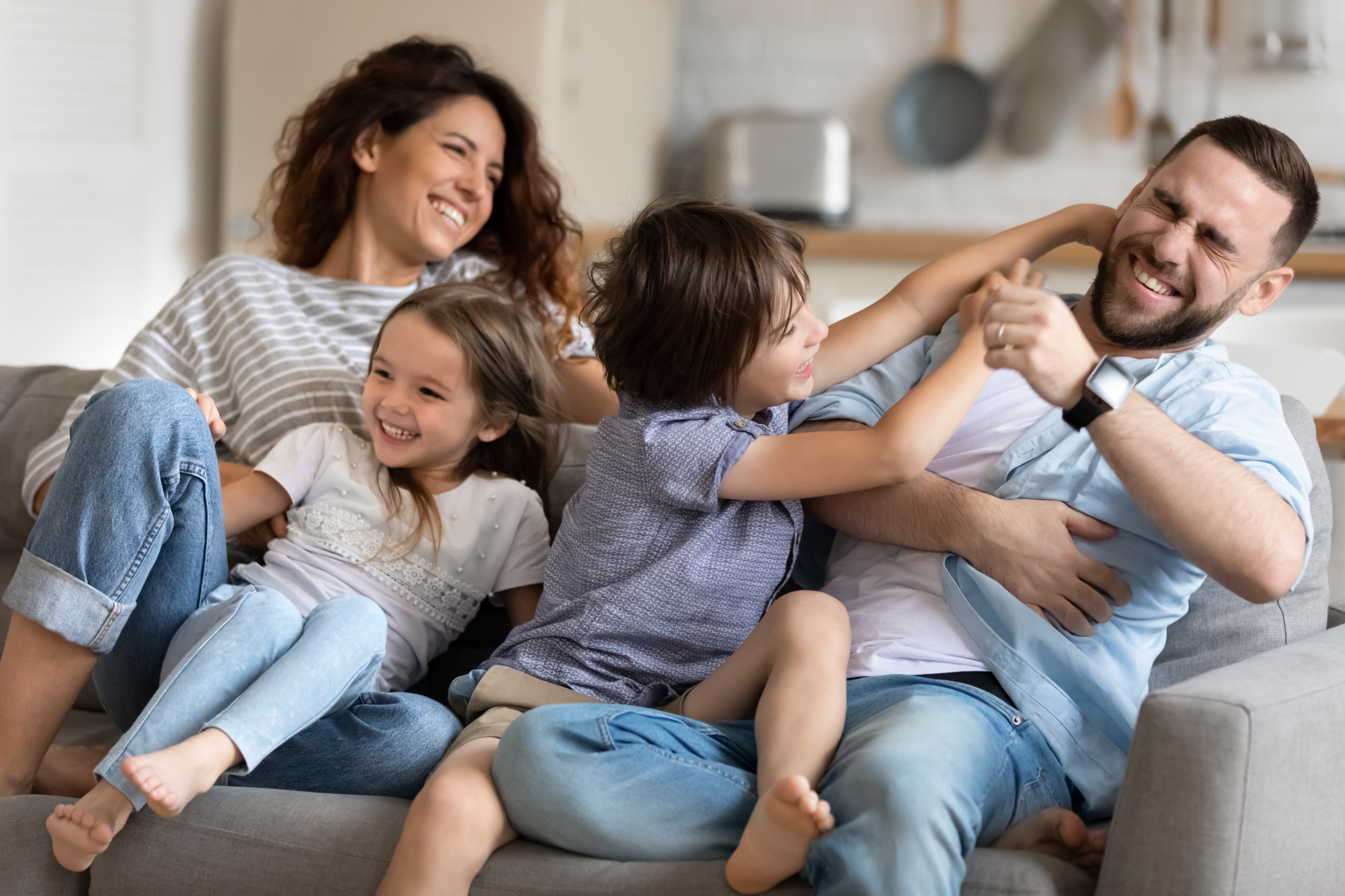 family of four playing together on a couch