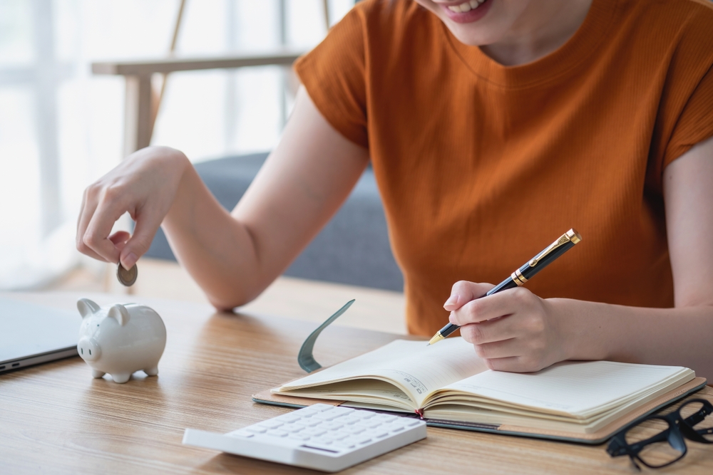 Woman putting money in piggy bank