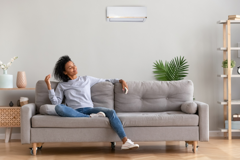 a woman relaxes on her couch after having maintenance performed on her ac system in West Chester, OH