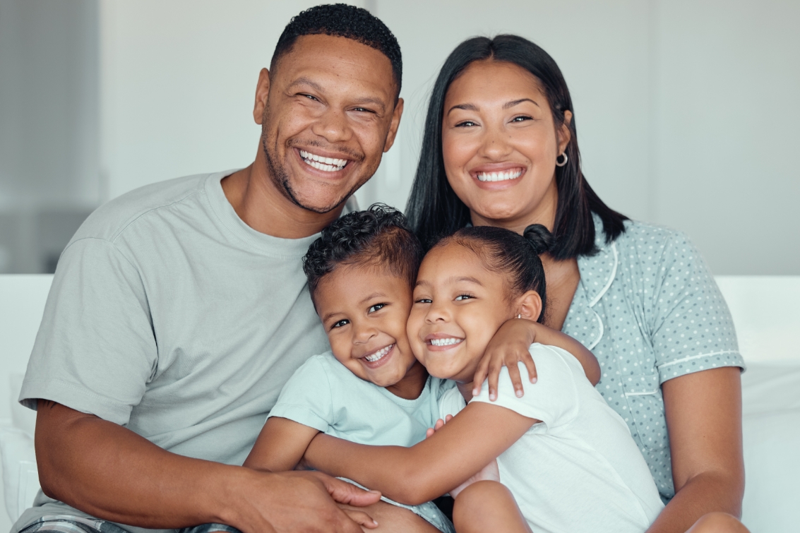 a mother and father pose for a family portrait with their two children in Mason, OH while waiting for furnace repair services